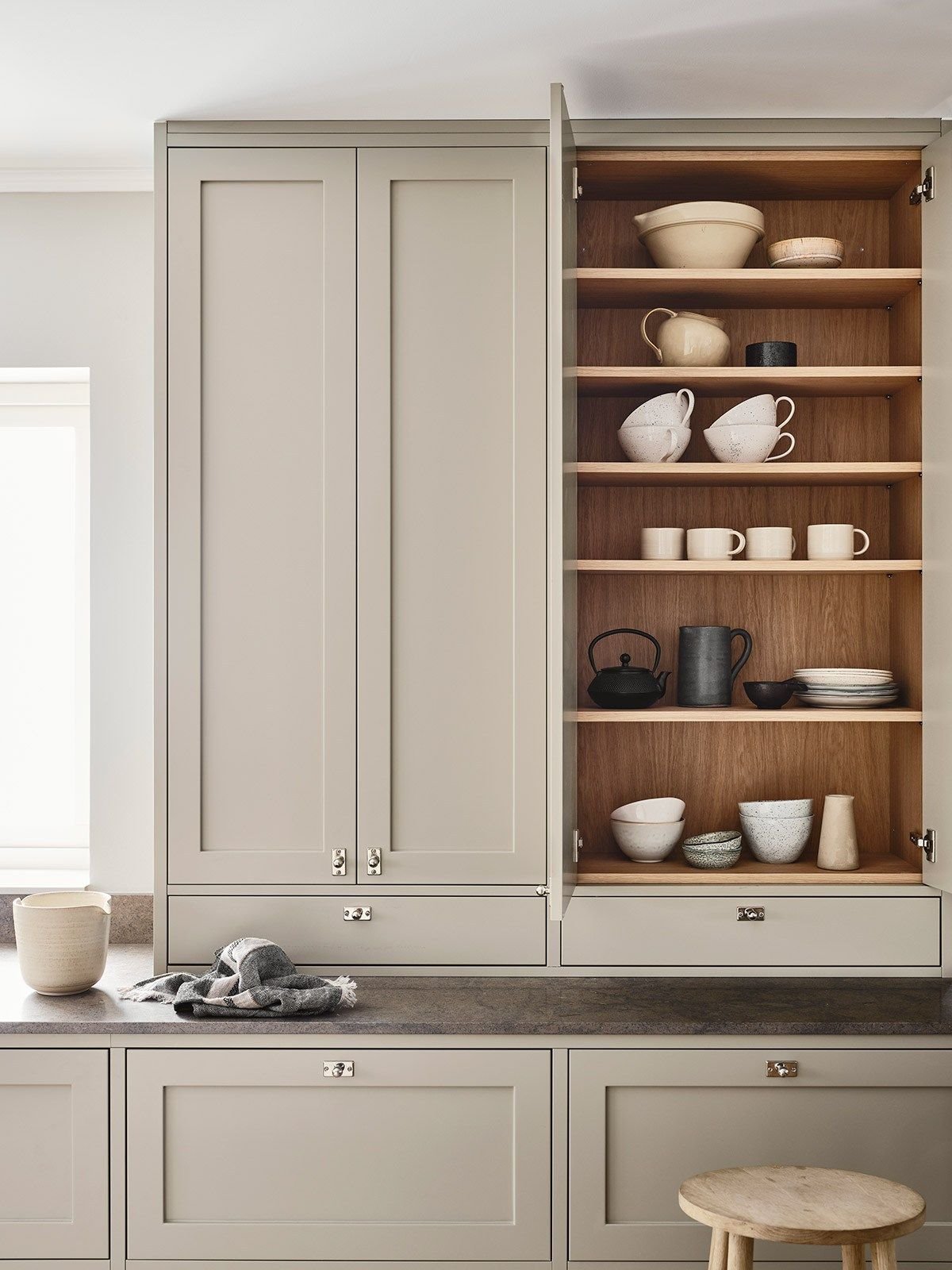 Cocina con estantes ordenados y frontales en color beige