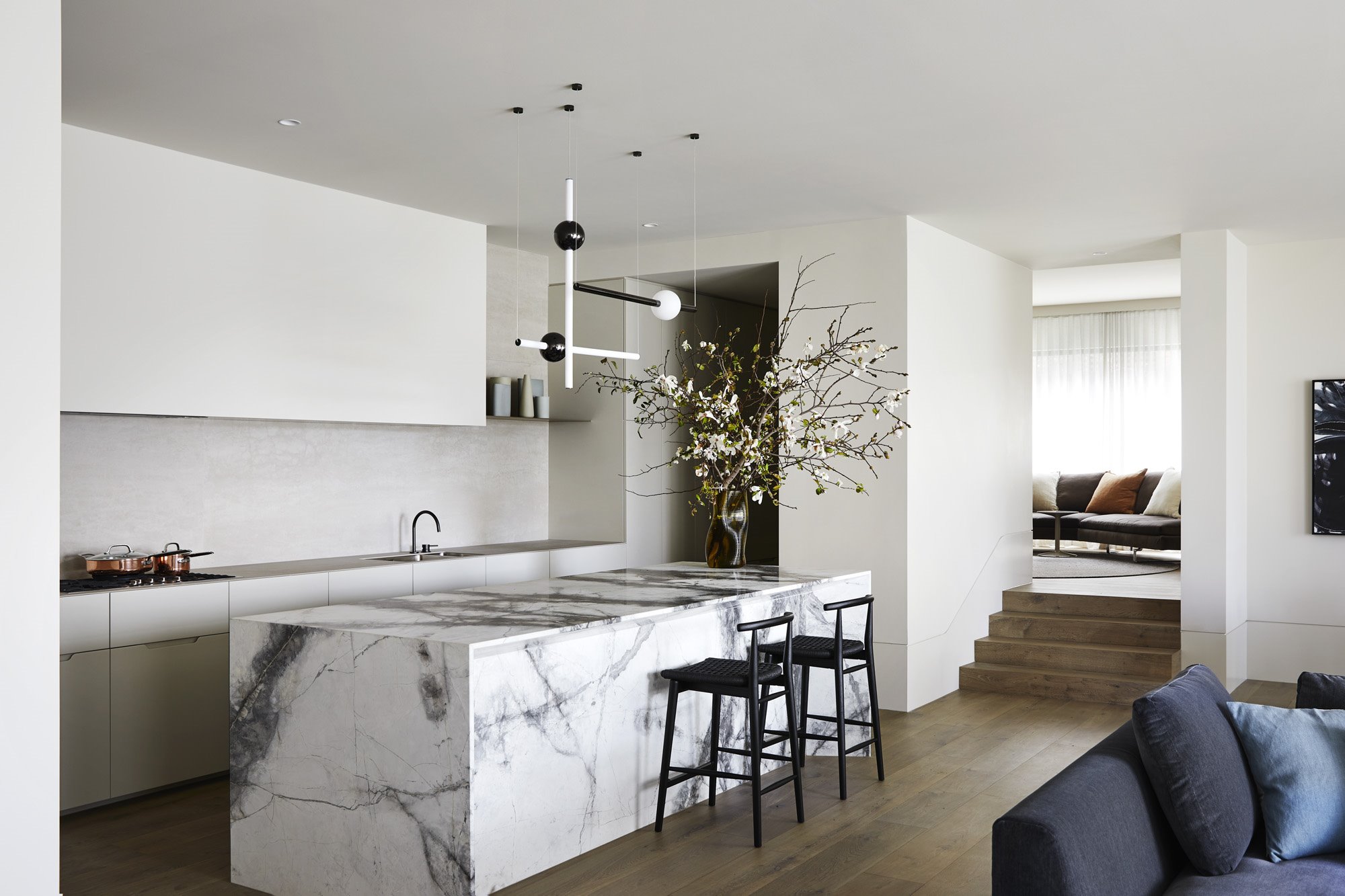 Cocina con isla de marmol y taburetes de color negro