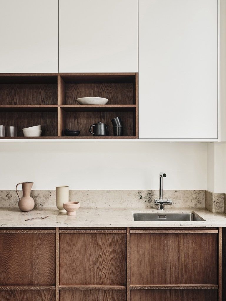 Cocina ordenada con frontales de madera y encimera de piedra
