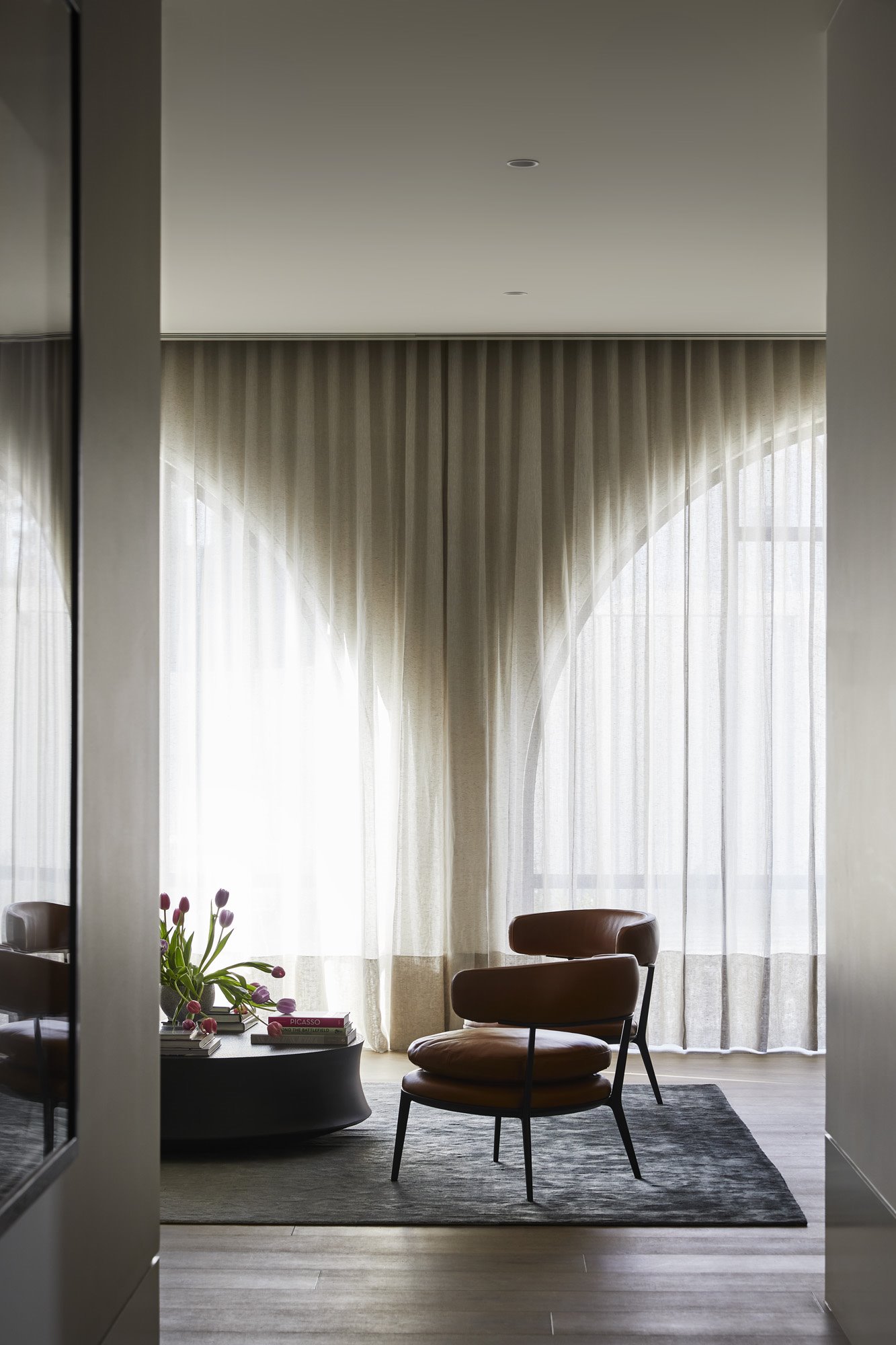 Salon con cortinas y butacas de piel marron