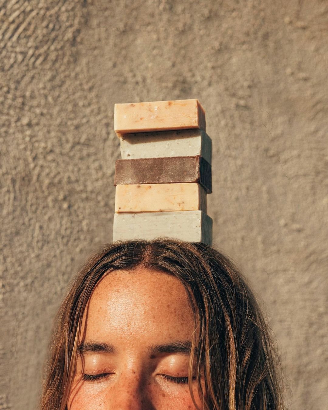 Mujer con jabones naturales sobre la cabeza