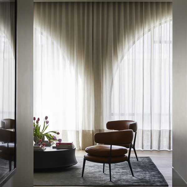 Salon con cortinas y butacas de piel marron