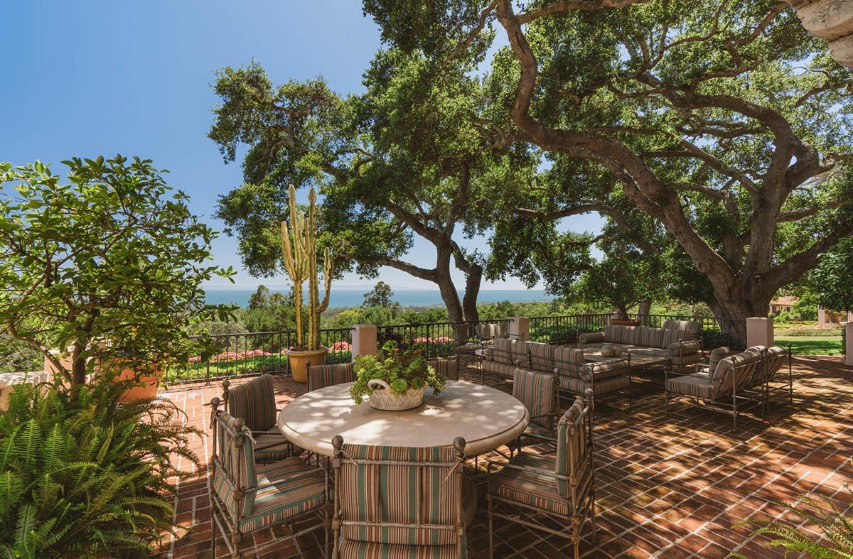 Jardin exterior con sillas de metal y mesas de piedra de la casa de Orlando Bloom y Katy Perry