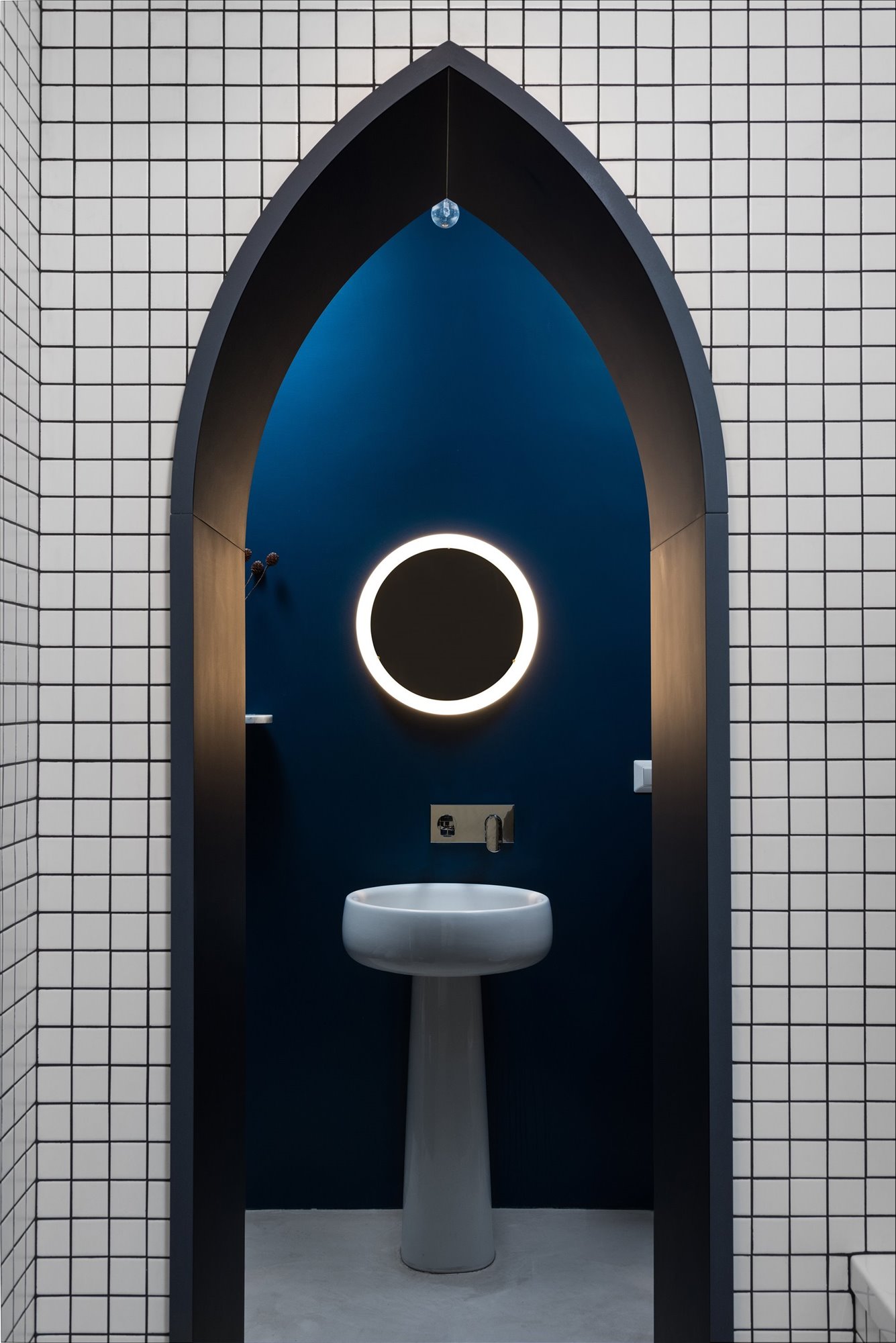 Baño con baldosas de color blanco y negro y arco de color azul de un piso en milan