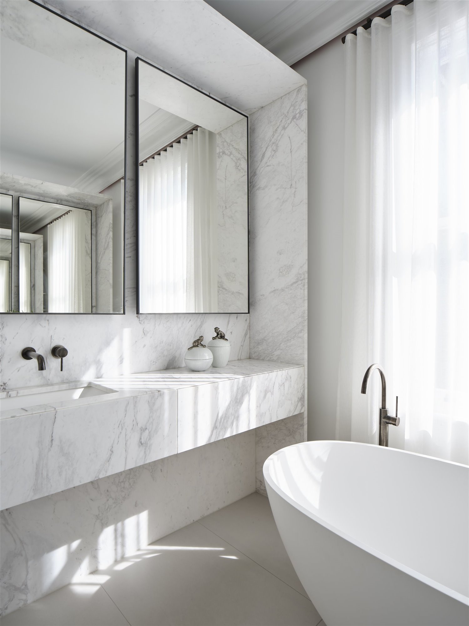 Baño de marmol blanco con espejos