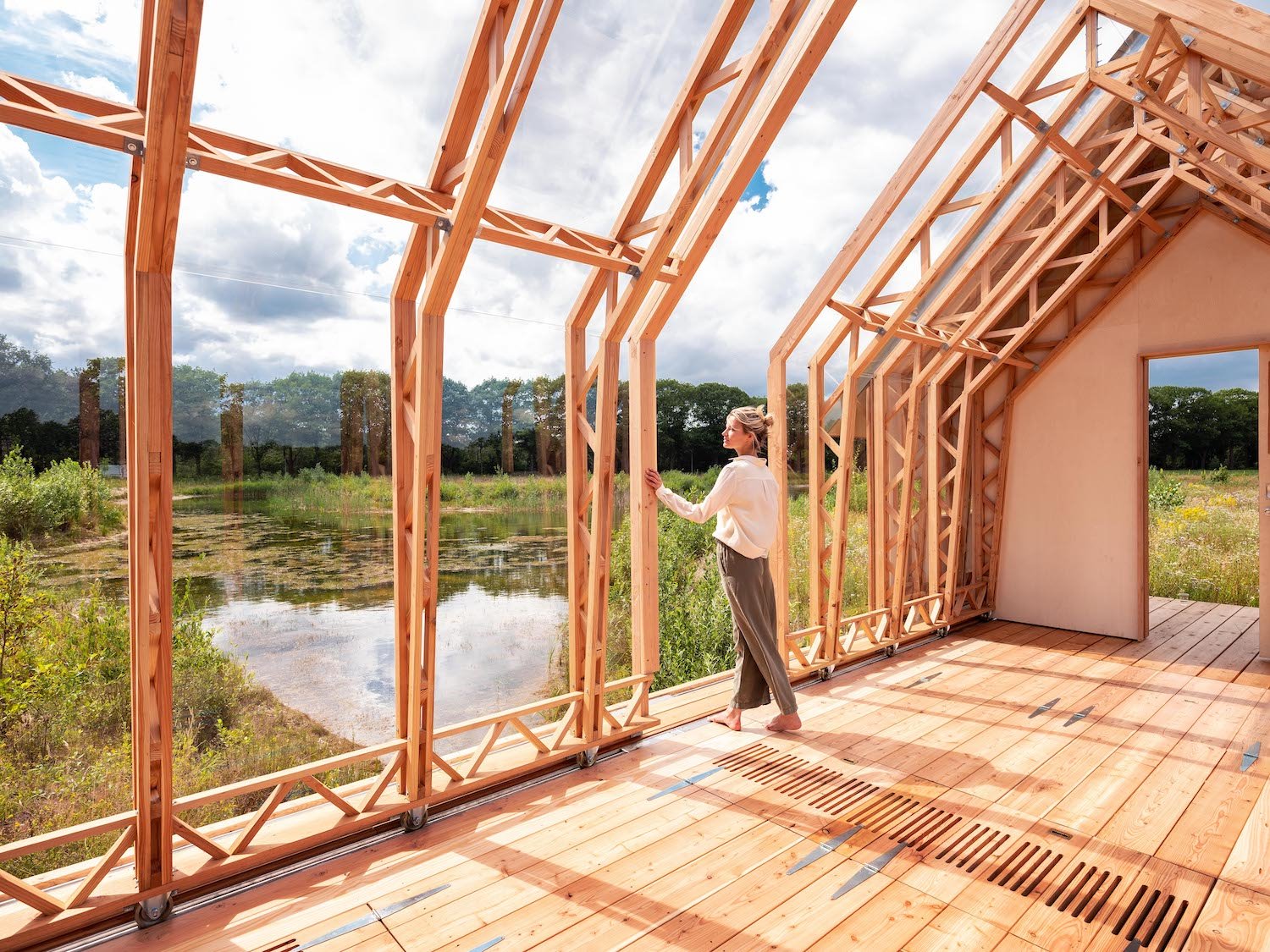 cabaña de madera con paredes de cristal en mitad del campo
