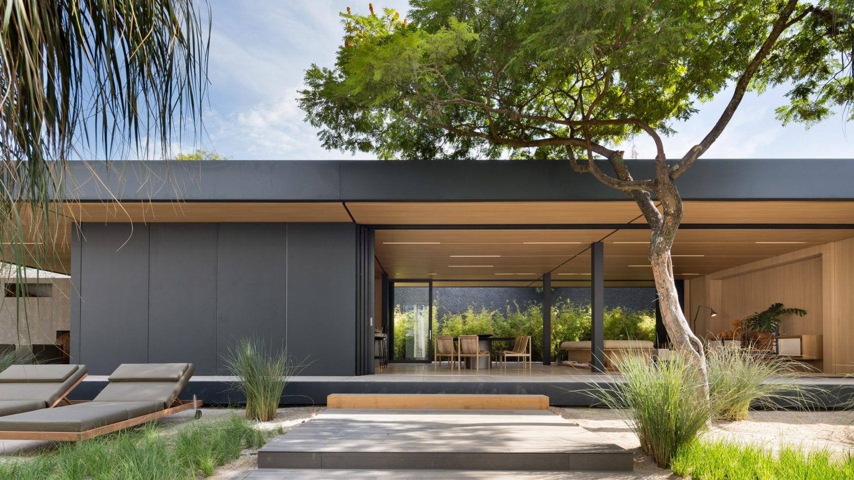 Casa prefabricada con fachada de color gris abierta en mitad del campo