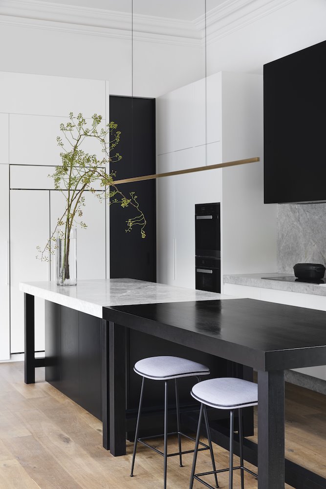 Cocina con isla de color gris y mesa en colro negro