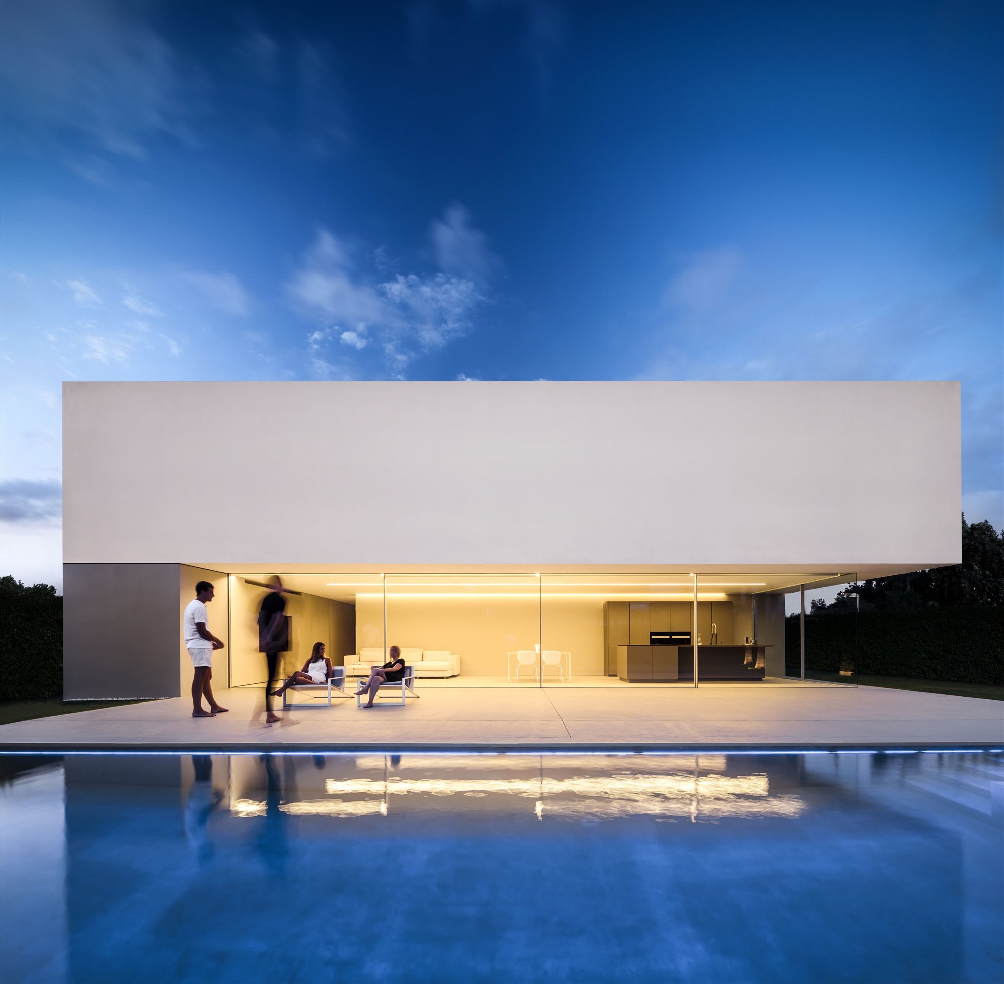 Fachada casa blanca moderna con una piscina vista de noche