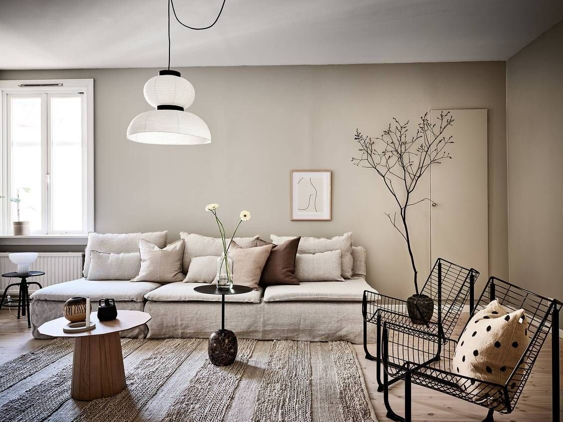 salon con lampara de papel paredes de color ocre y sofa en color beige