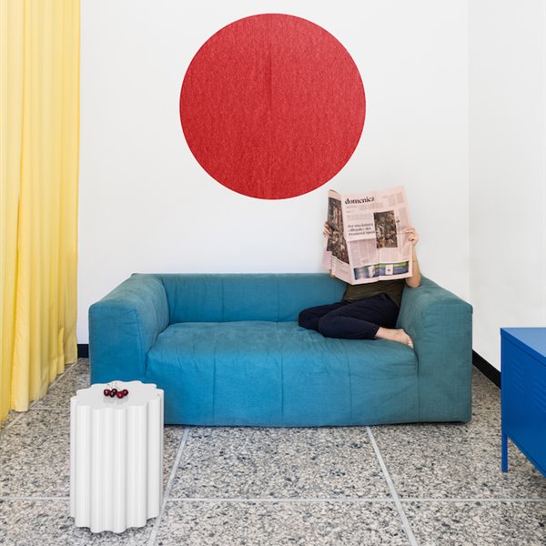 Salon con sofa y cuadro redondo de color rojo de un piso en milan