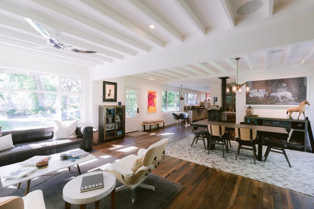 Salon con vigas blancas y butacas eames de la la casa de Reese Witherspon