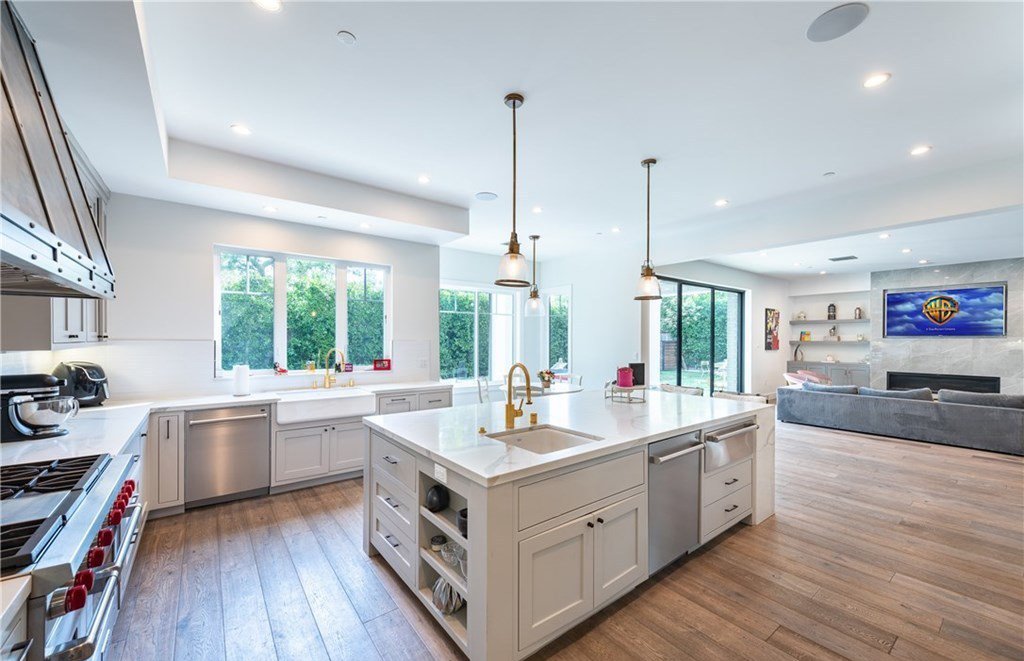 Casa de Ariel Winter la actriz de la serie Modern Family cocina en isla con suelo de madera