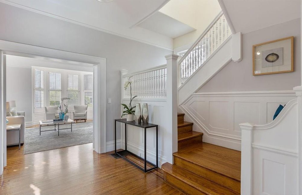 Recibidor con escalera de color blanca de la casa de Winona Ryder en San Francisco