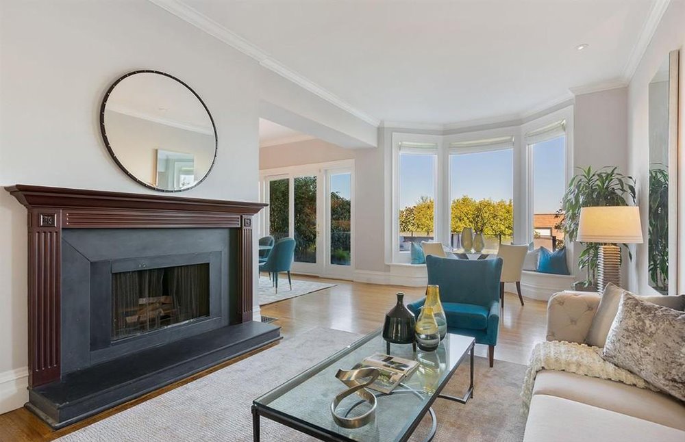 Salon con chimenea y butaca azul turquesa de la casa de Winona Ryder en San Francisco
