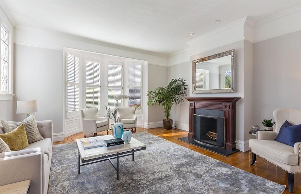 Salon con chimenea y ventanas con estores y lamas de la casa de Winona Ryder en San Francisco