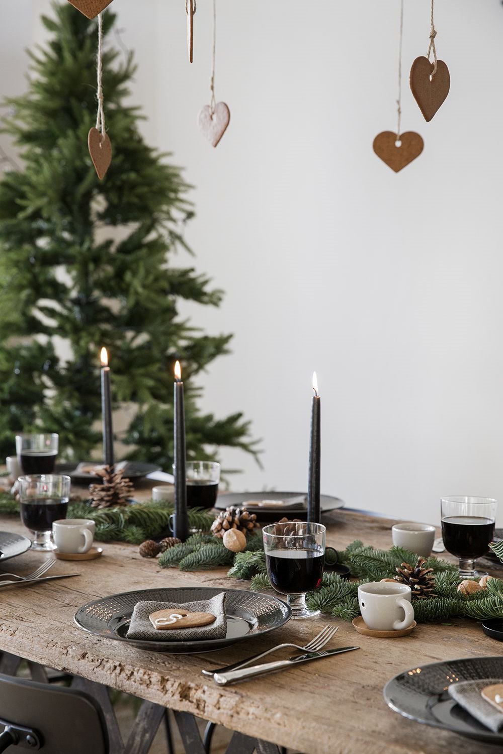 Mesa con decoracion de plantas de pino y colgantes de galletas de jengibre. Aprovecha la naturaleza