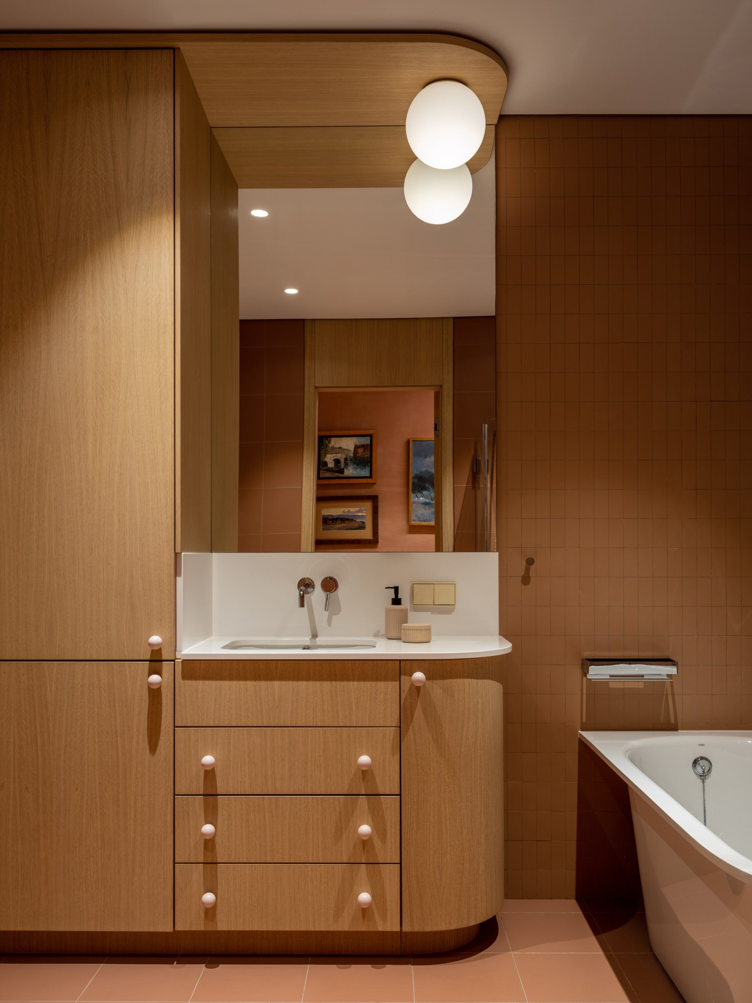 Baño con mueble de madera redondeado de un piso en Moscu reformado por Agnes Rudzite