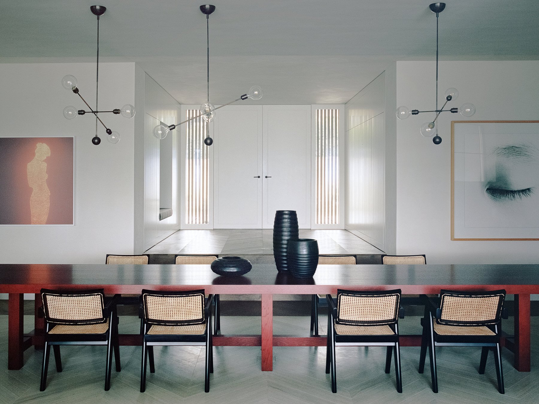 Comedor con mesa de color rojo y lamparas de techo de una casa en el lago de zurich