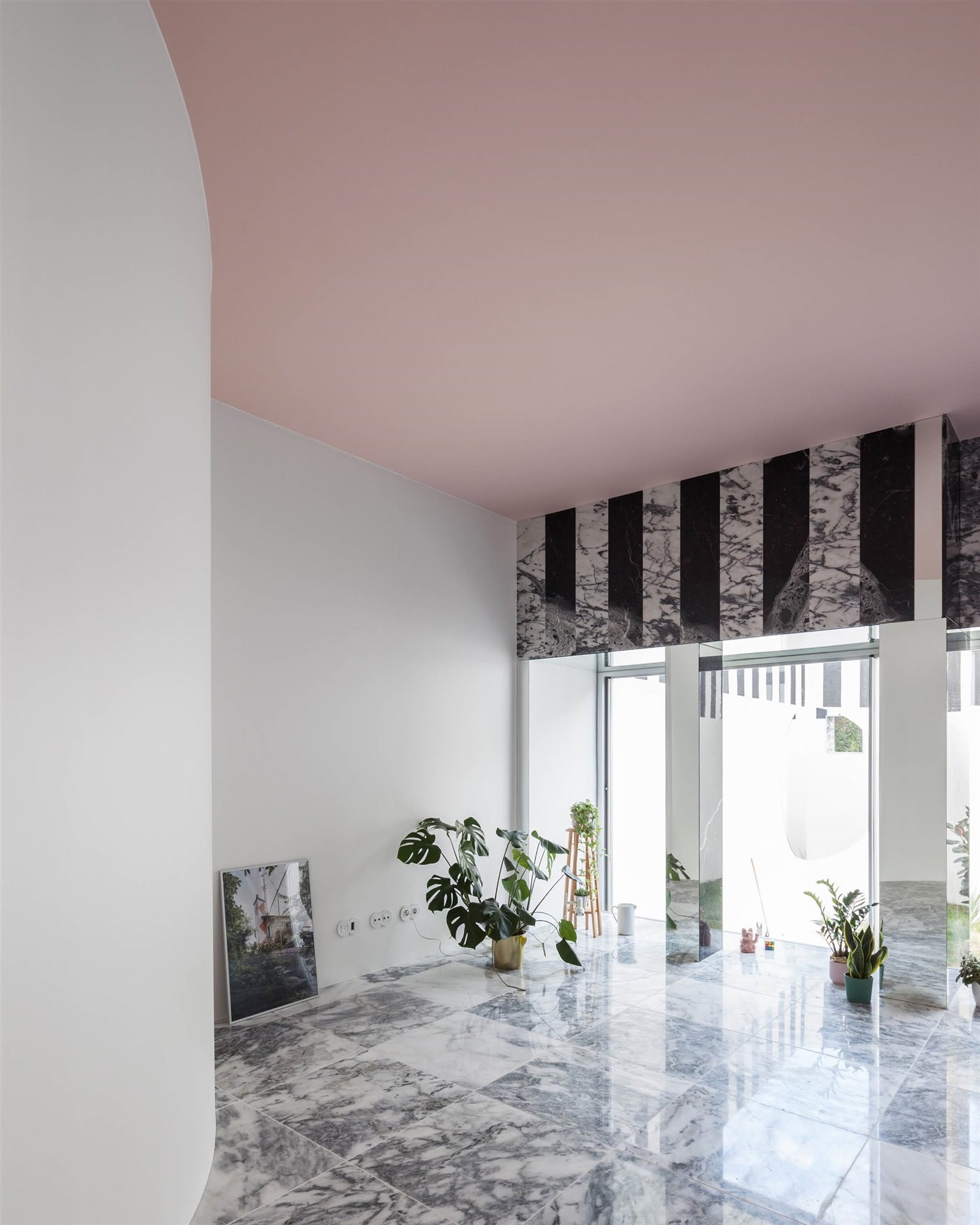 Interior de un piso reformado por Fala Atelier en Porto con suelos de piedra y techos de color rosa