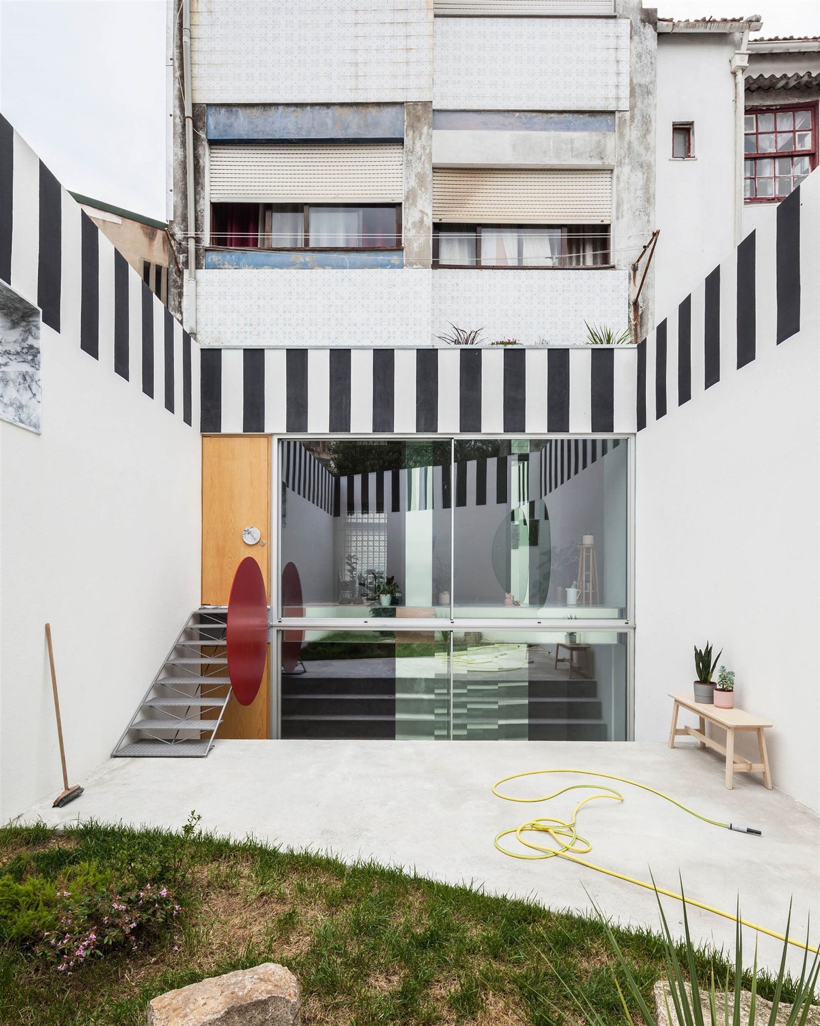 Patio interior con paredes de cristal de un piso reformado por Fala Atelier en Portugal