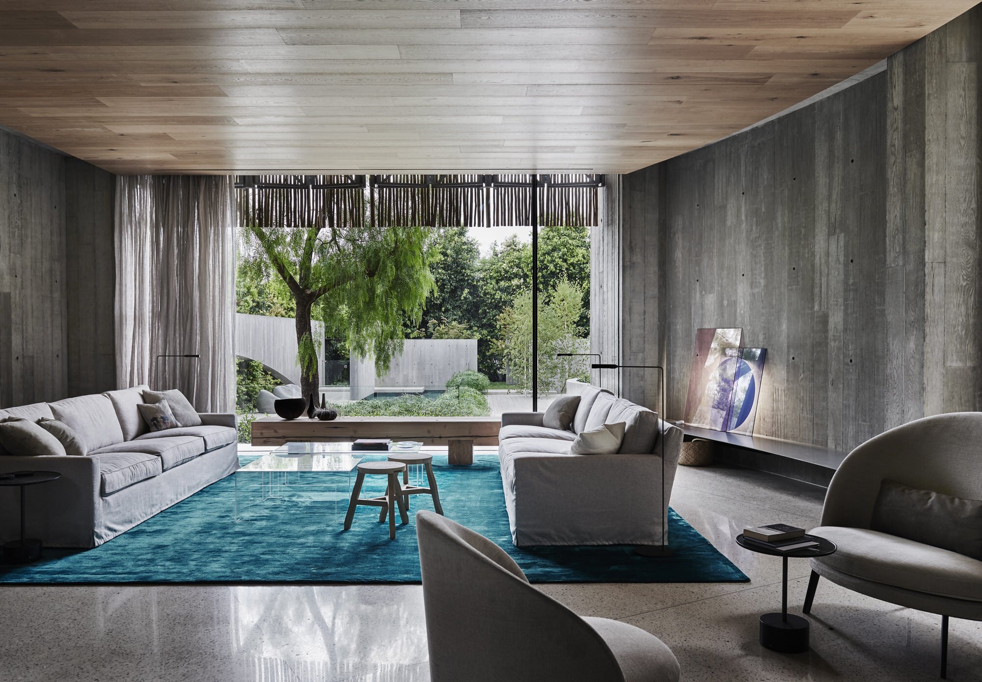 Salon con sofas de color gris y alfombra en color turquesa de una casa en Australia