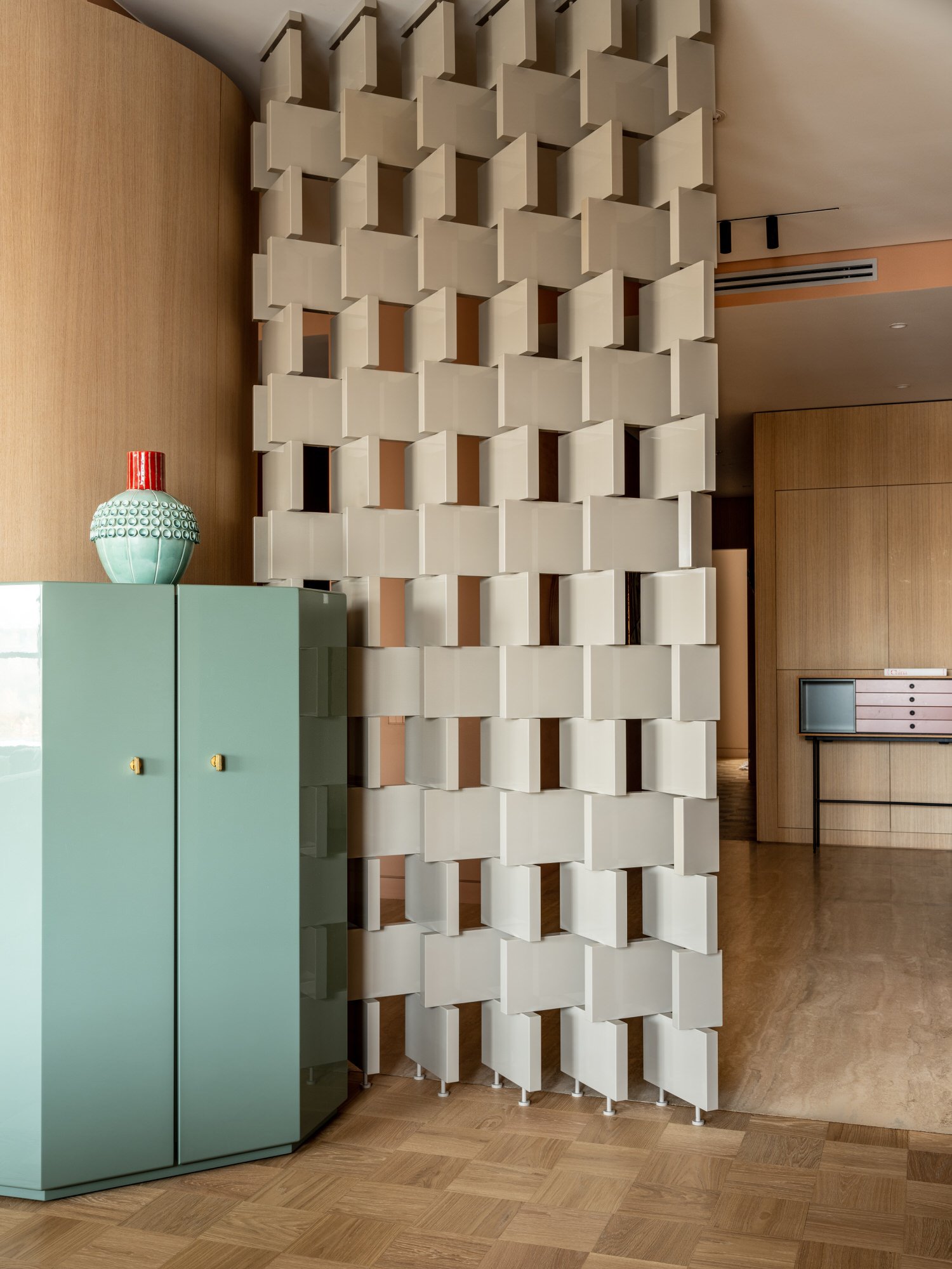 Separador en el recibidor tipo celosia y mueble de color turquesa de un piso en Moscu reformado por Agnes Rudzite