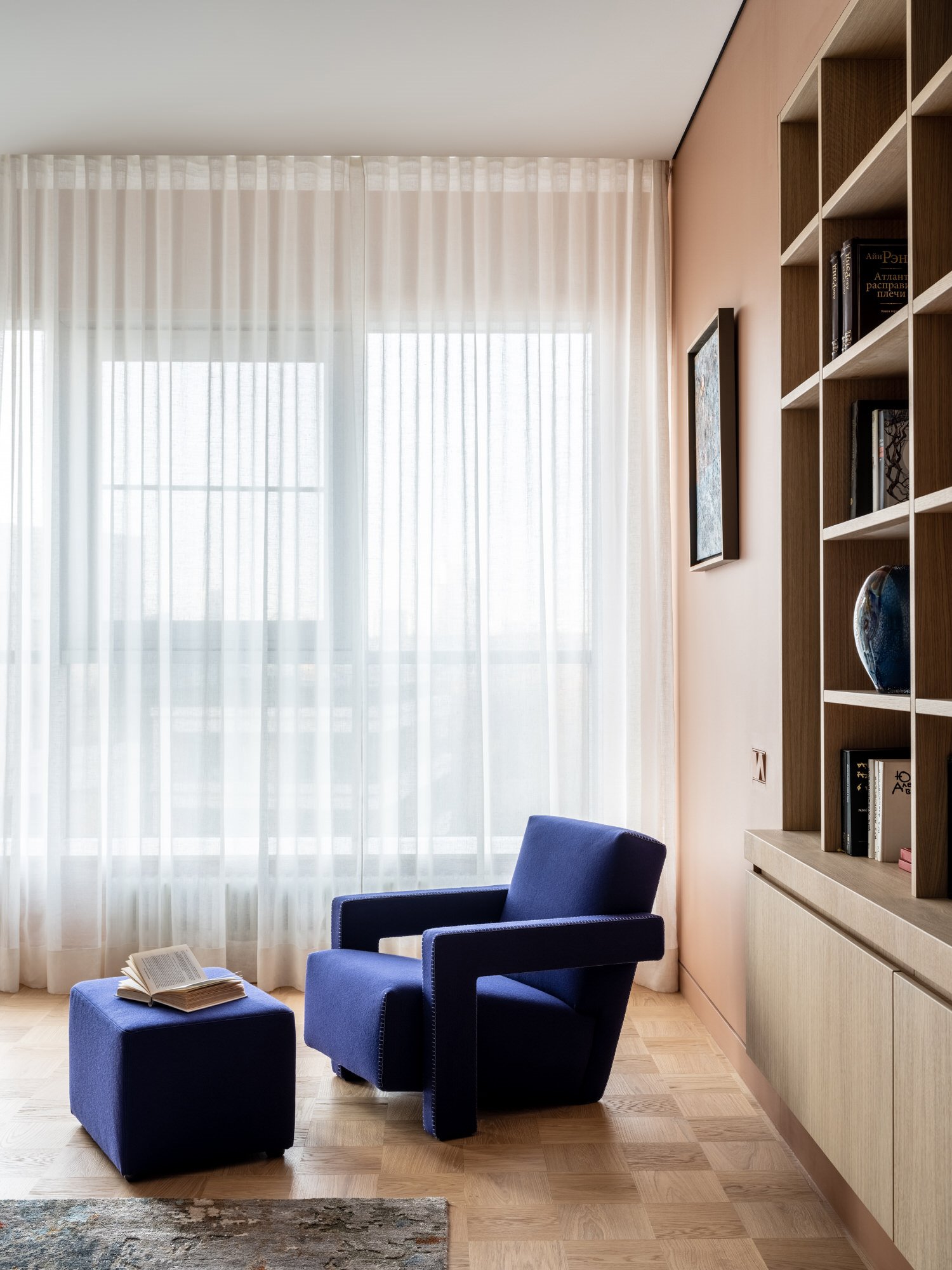 Zona de lectura con una silla de cassina en color azul de un piso en Moscu reformado por Agnes Rudzite