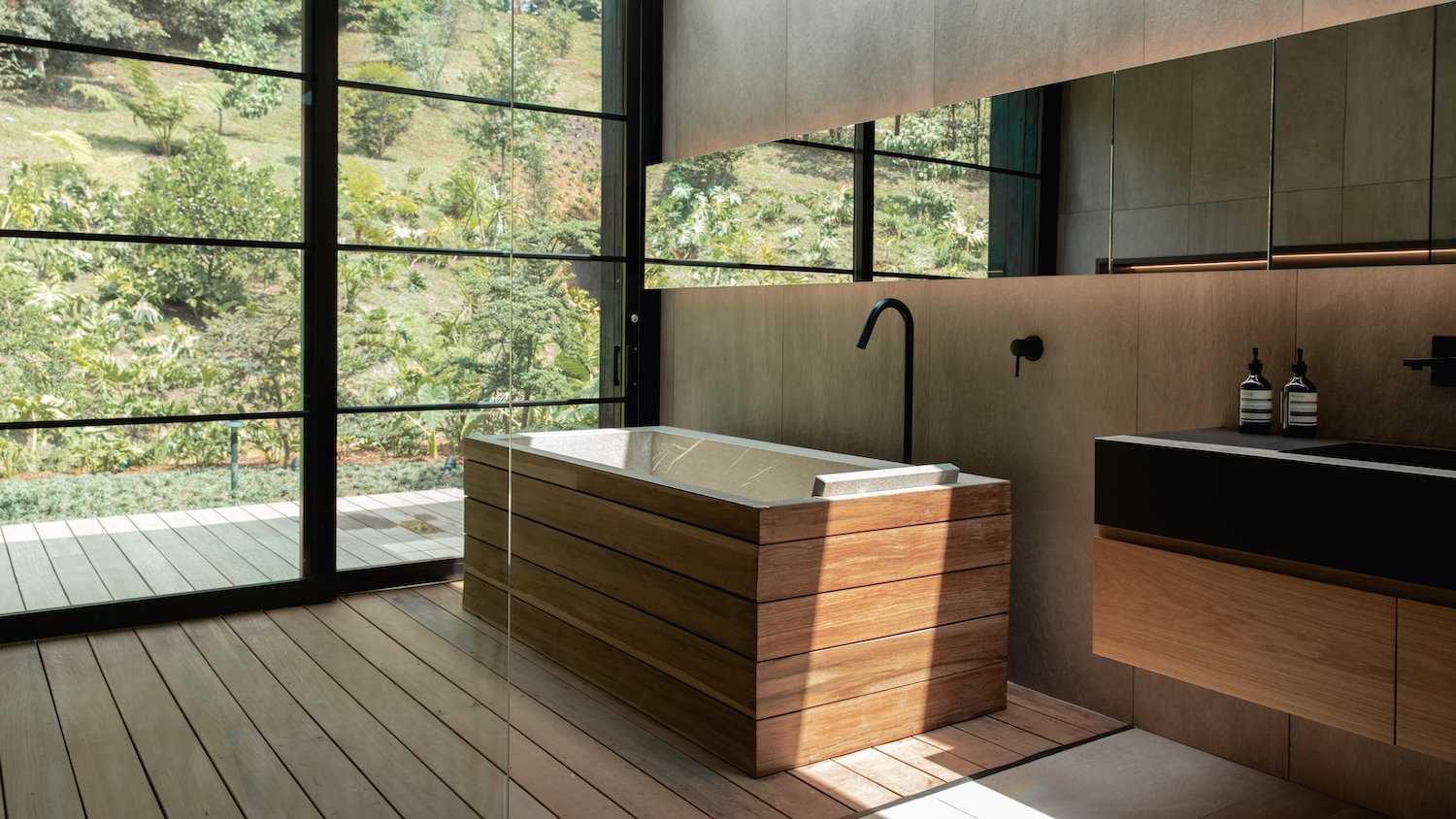 Baño con bañera de madera de estilo japones de la casa del cantante J Balwin en Medellin