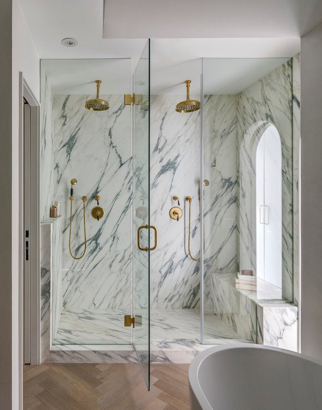 Baño con ducha con giferias doradas de un piso en nueva york