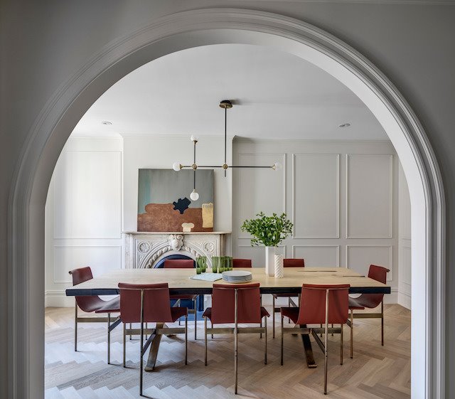Comedor con molduras y mesa de madera y sillas de piel