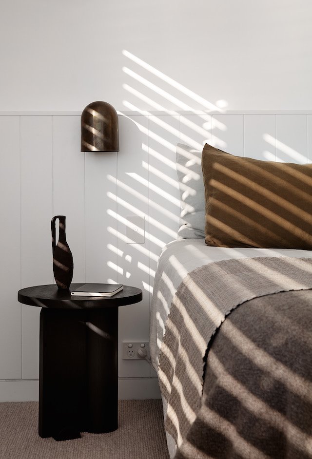 Dormitorio con mesilla auxiliar de color negro