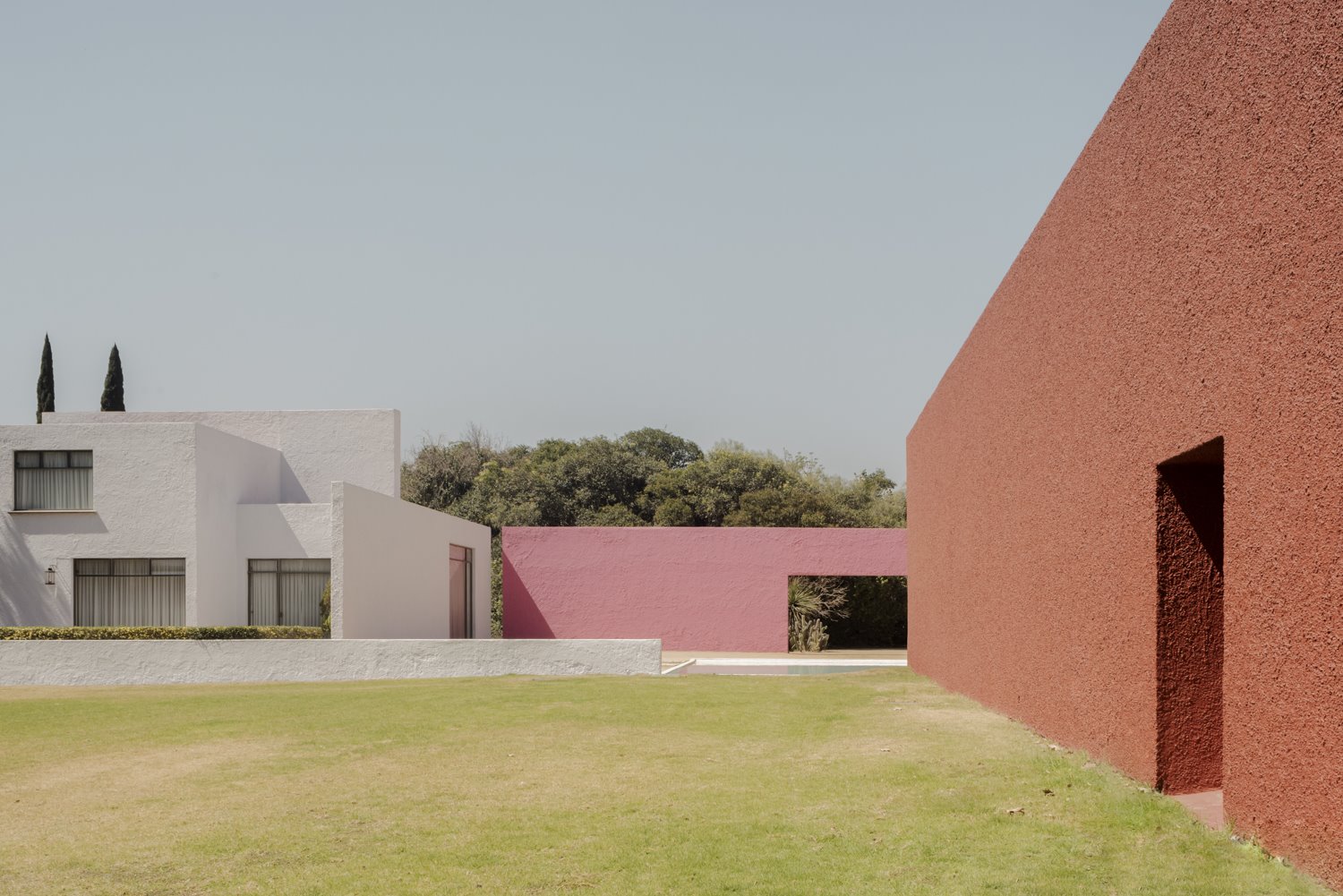 Patio con edificios fachadas en color terracota y color rosa del arquitecto mexicano Luis Barragan