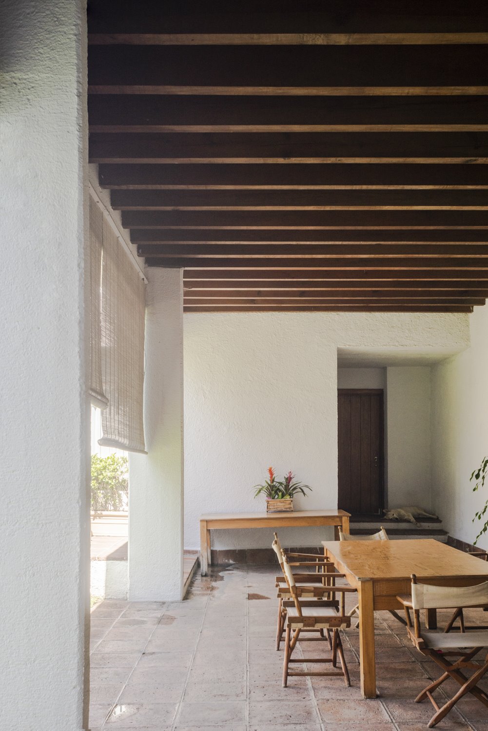 Patio con vigas y una mesa de comedor de un edificio del arquitecto mexicano Luis Barragan