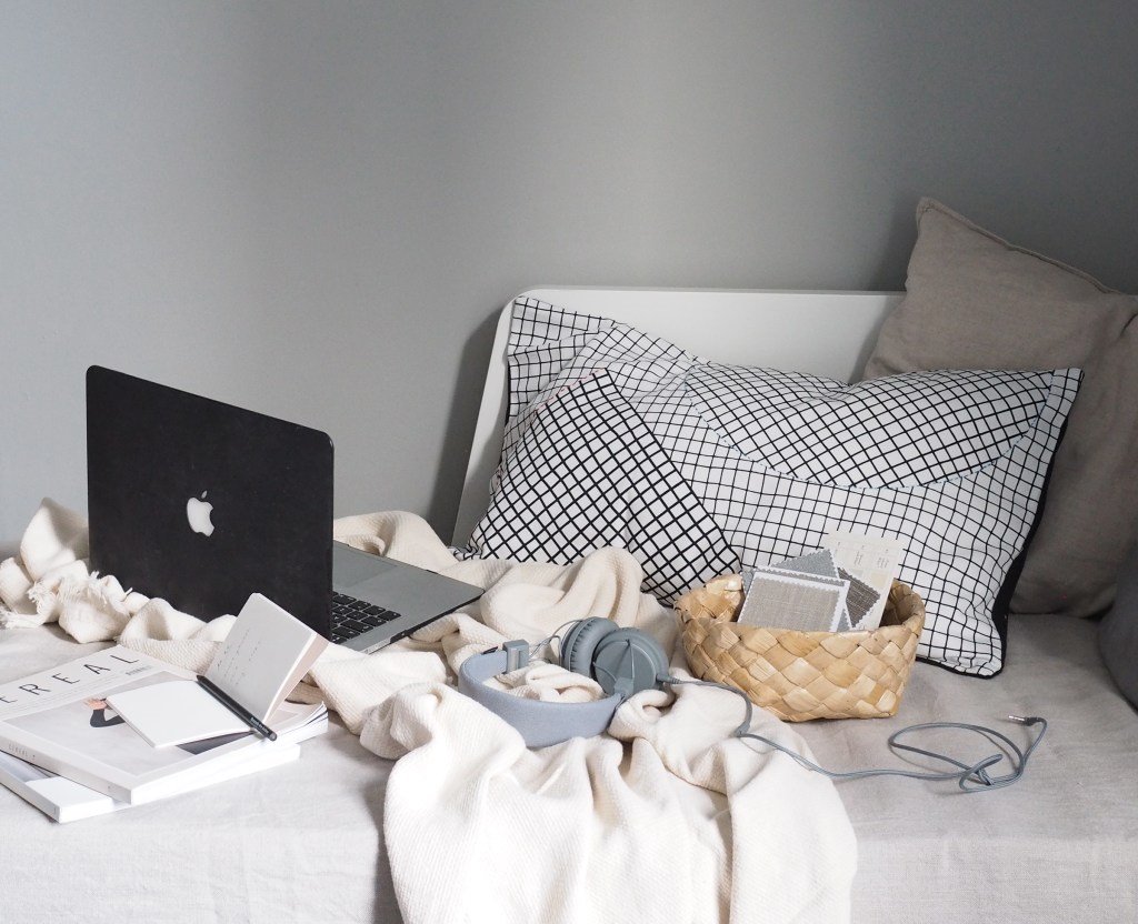 Dormitorio con cojines y ordenador
