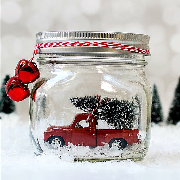 Cochecito de color rojo para decorar la casa en navidad con un bote de cristal