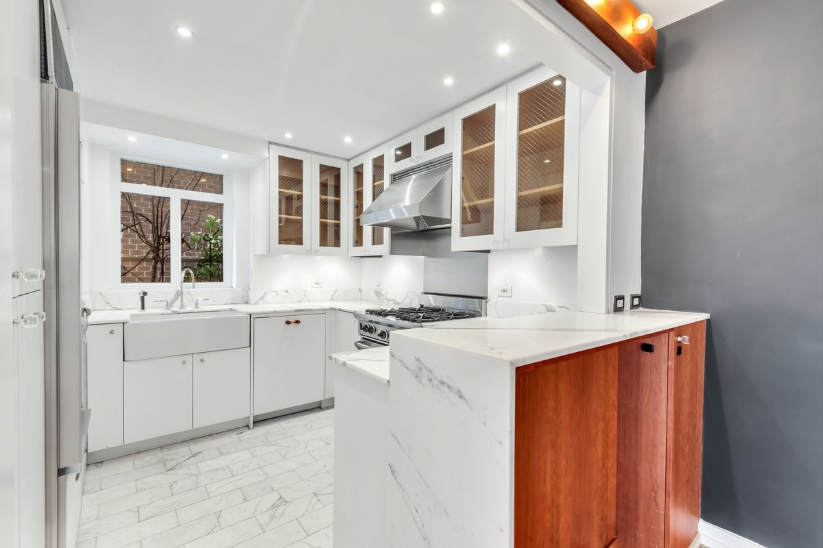 Cocina pequeña con muebles en color blanco de la casa de Scarlett Johansson en Nueva York