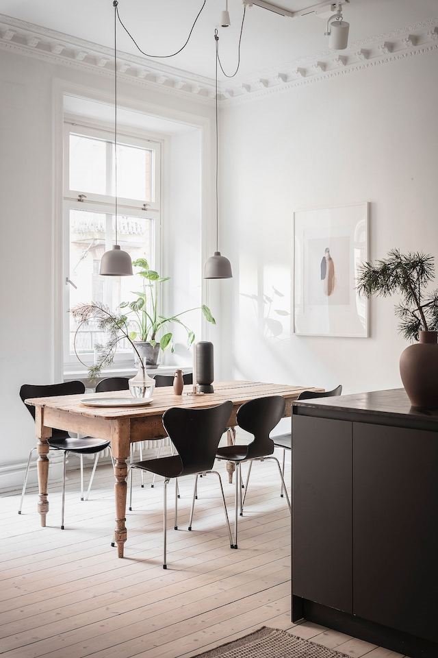 Apartamento en estocolmo comedor con sillas de color negro y mesa de madera