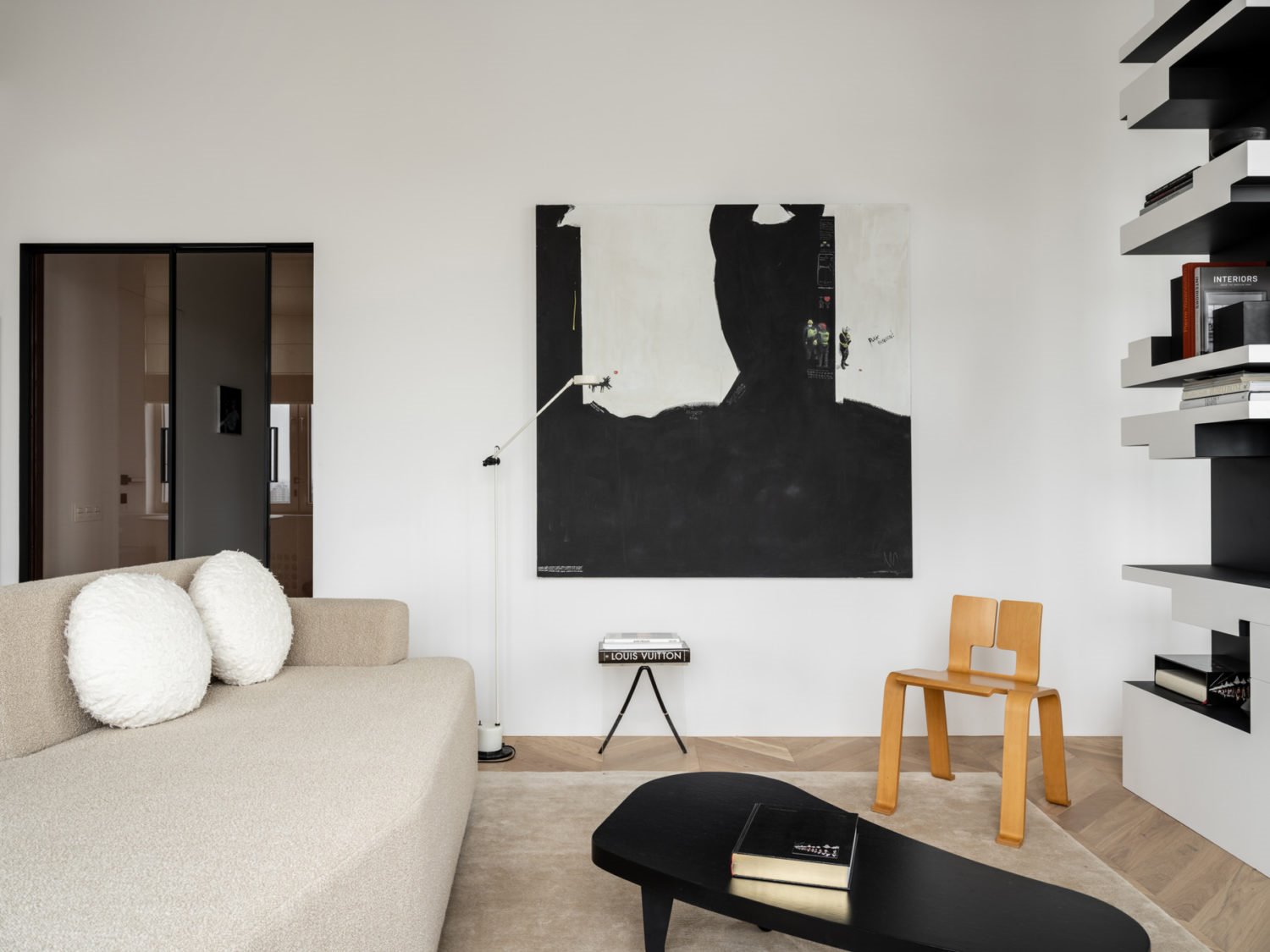 Piso en moscu en blanco y negro salon con obras de arte y sofa