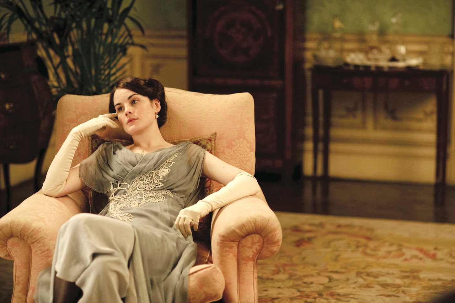 Sofa de terciopelo rosa alfombras y mesillas de madera de la serie Downtown Abbey