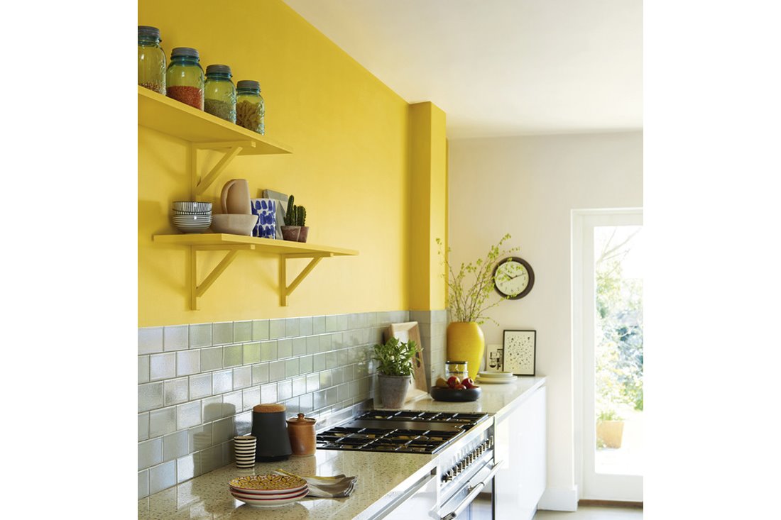 Cocina con paredes pintadas en color amarillo y azulejos de color gris