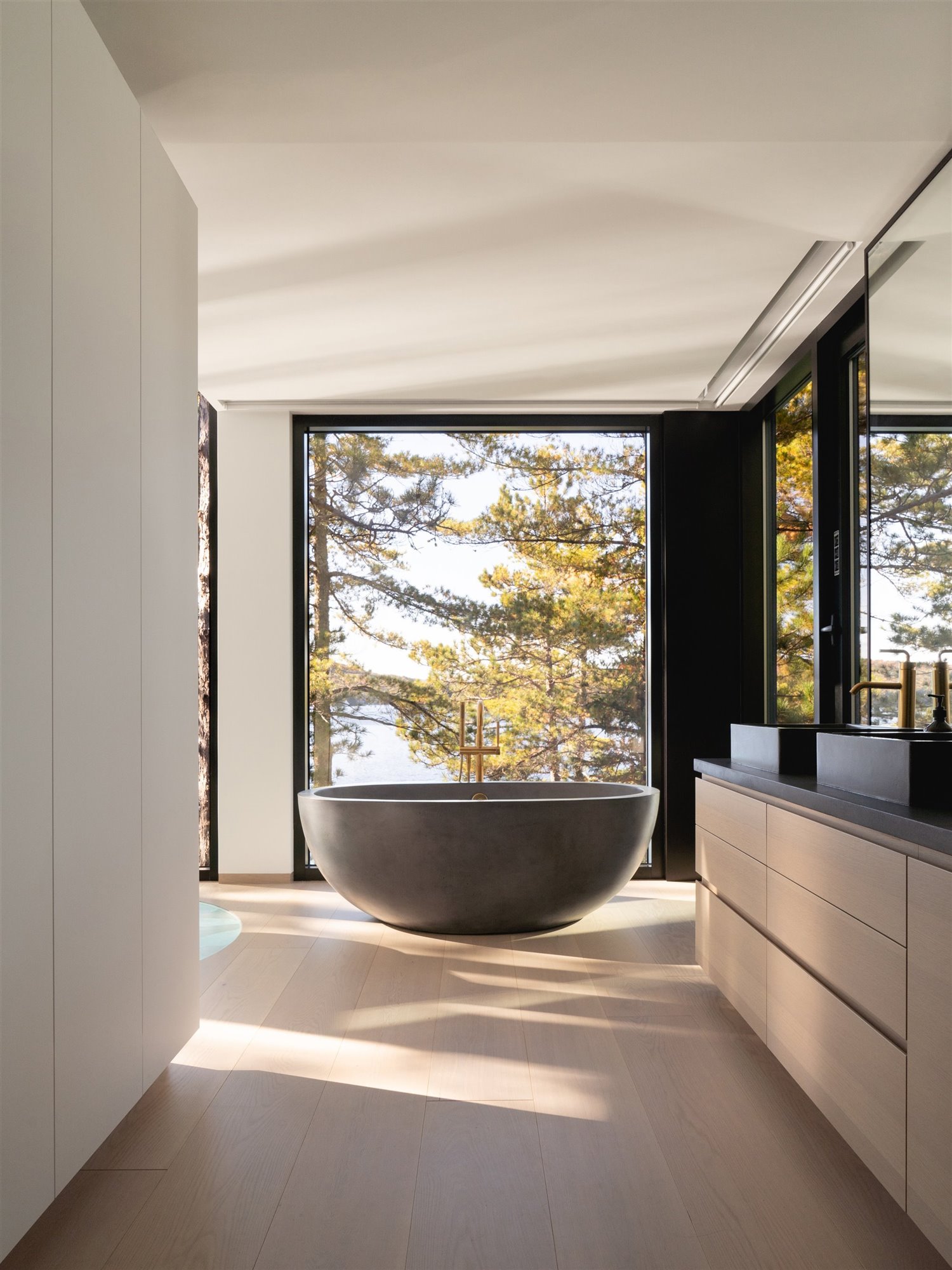Baño con bañera de una casa en Montreal con vistas un bosque