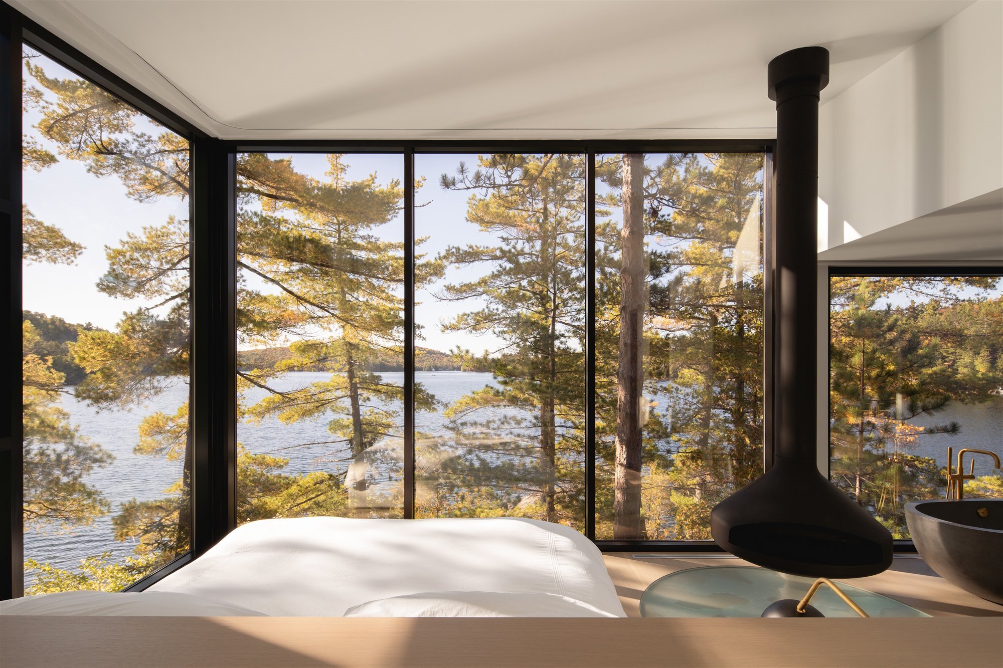 Dormitorio con vistas a un lago de una casa en Montreal con chimenea negra