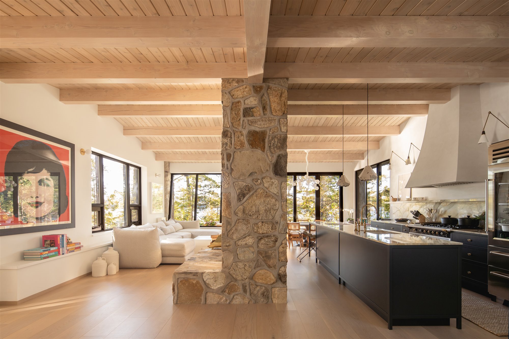 Salon cocina comedor de una casa con chimenea de piedra en montreal