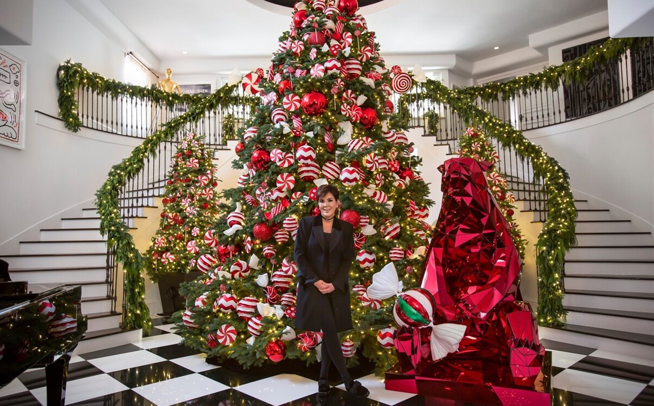 La escalera de la mansión de Kris Jenner decorada con un árbol de Navidad recargado y lleno de regalos.