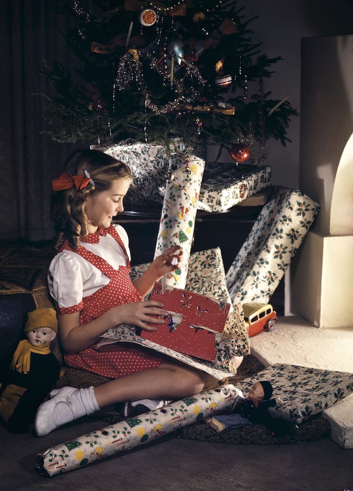 Niña con regalos y envoltorios de Navidad. 1961