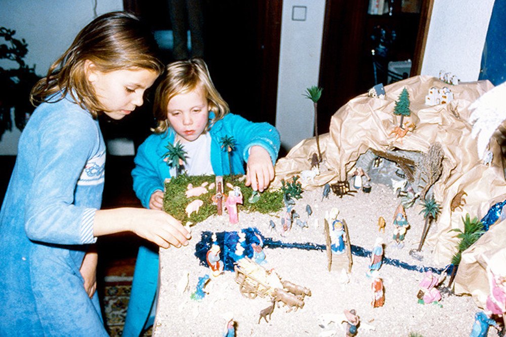 Niñas en pijama con un belen de Navidad. 1979