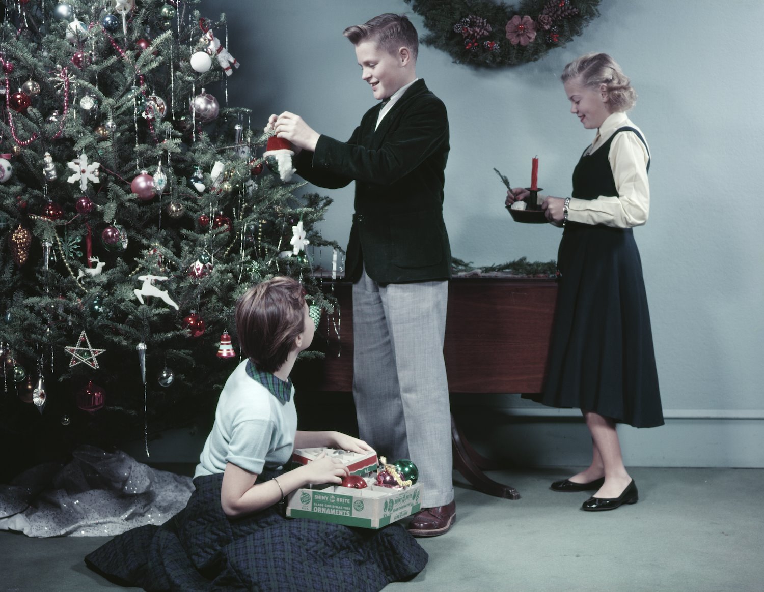 Niños decorando un arbol de navidad en los años cincuenta