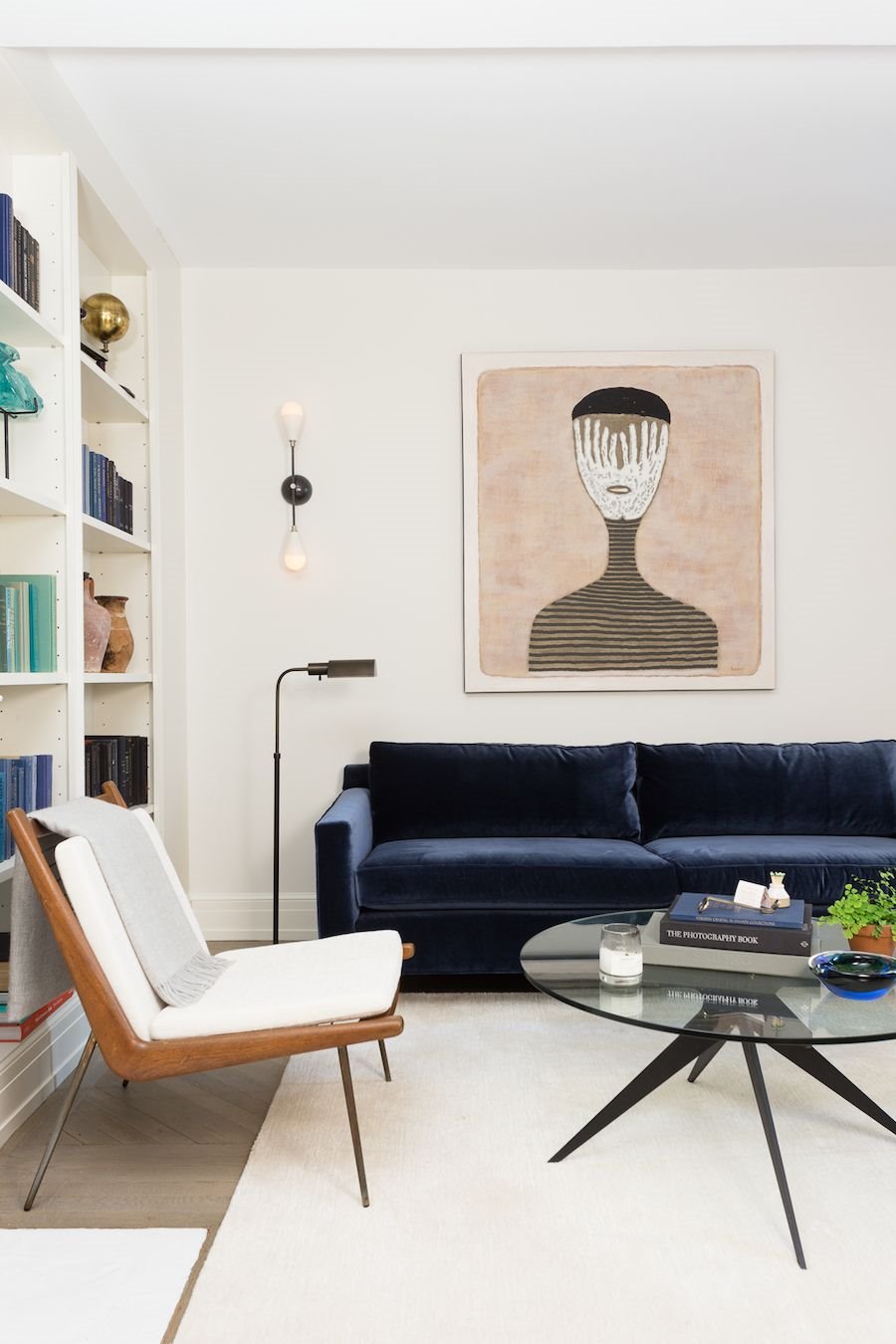 Sofa de terciopelo azul en salon con alfombra de color blanco. Abraza el terciopelo