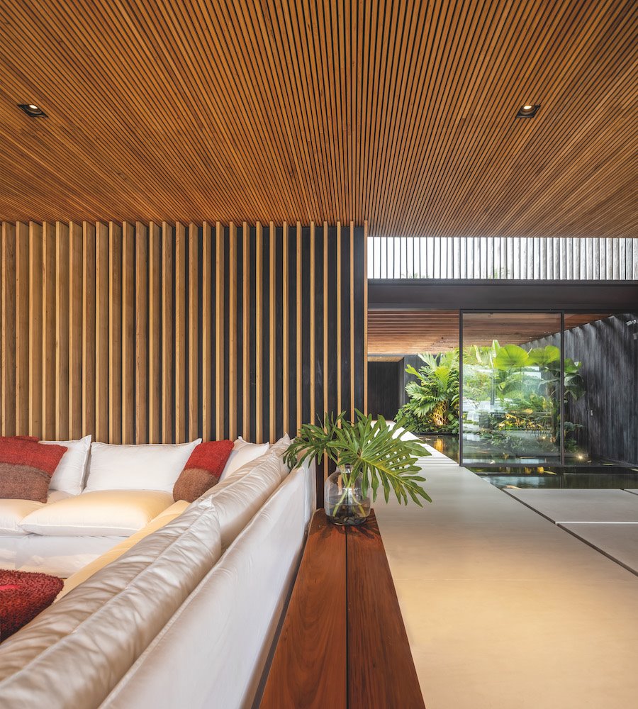 Salon con paredes de lamas de madera de una casa en Brasil